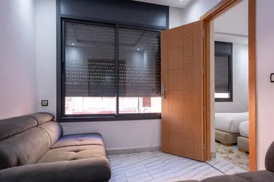 a living room with a couch and a window at Bright Flat in Heart of Center in Marrakech