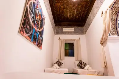 a room with two beds and a ceiling with paintings at Riad Sala Art Marrakech in Marrakech