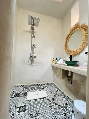 a bathroom with a black and white tile floor at Riad Sala Art Marrakech in Marrakech