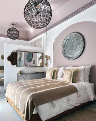 a bedroom with a large bed with two plates on the wall at Riad Jalma in Marrakech