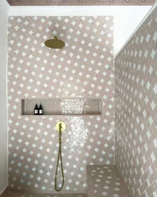 a bathroom with a shower with a tile wall at Riad Jalma in Marrakech