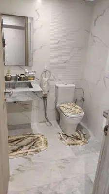 a white bathroom with a toilet and a sink at Dream Land Duplex for families in Marrakech