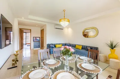 a dining room with a glass table and a blue couch at New! App avec Vue sur Piscine à Noria Golf in Marrakech