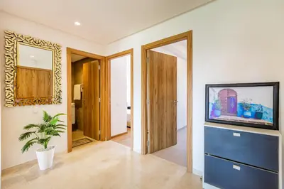 a living room with a tv and a blue dresser at New! App avec Vue sur Piscine à Noria Golf in Marrakech