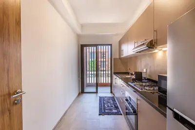 a kitchen with a counter and a stove top oven at New! App avec Vue sur Piscine à Noria Golf in Marrakech
