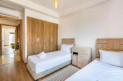 a bedroom with two beds and a dresser at New! App avec Vue sur Piscine à Noria Golf in Marrakech