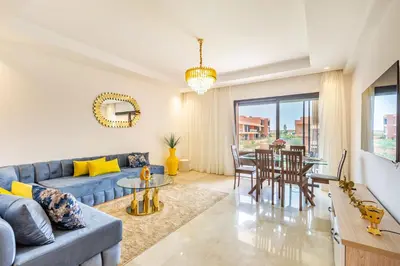 a living room with a blue couch and a table at New! App avec Vue sur Piscine à Noria Golf in Marrakech