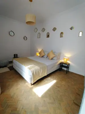 a bedroom with a large bed with two lamps on it at Riad L'Arganier in Marrakech