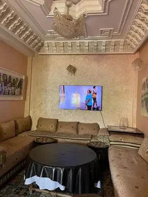 a living room with a couch and a flat screen tv at Dar Bensoussen in Marrakech
