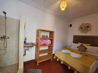 a small bedroom with a bed and a shower at Riad Córdoba in Marrakech