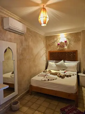 a bedroom with a bed with a mirror and shoes on it at Riad Córdoba in Marrakech