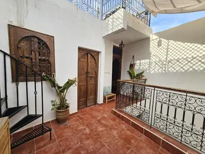 a foyer with a staircase and a wooden door at Riad Córdoba in Marrakech