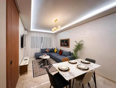 a living room with a blue couch and a table at Appartement de Luxe bien équipé in Marrakech