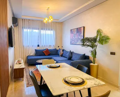 a living room with a blue couch and a table at Prestigieux Appartement in Marrakech
