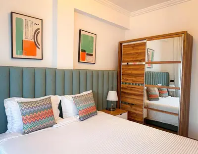 a bedroom with a bed with a green headboard at Prestigieux Appartement in Marrakech