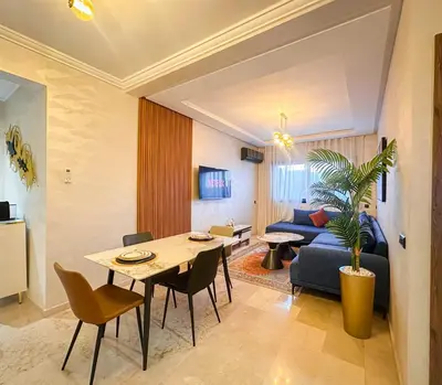 a living room with a table and a couch at Prestigieux Appartement in Marrakech