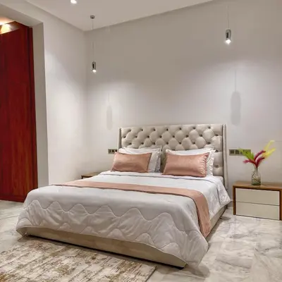 a bedroom with a large bed with pink pillows at villa argan golf piscine chauffée in Marrakech