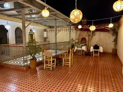 a dining room with tables and chairs and lights at Riad Tislite & SPA in Marrakech