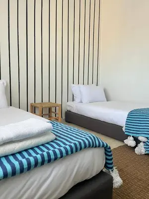 a bedroom with two beds and a striped wall at Designer Gueliz Penthouse - Terrace - Atlas Views in Marrakech