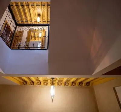 a room with a ceiling with a chandelier and a window at Authentic house in the old Medina of Marrakech in Marrakech