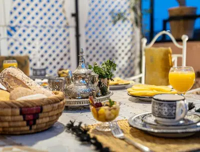 a table with food and a glass of orange juice at Authentic house in the old Medina of Marrakech in Marrakech