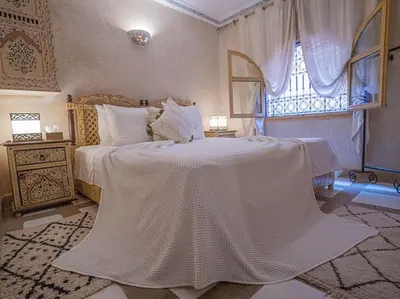a bedroom with a large white bed with a window at Authentic house in the old Medina of Marrakech in Marrakech