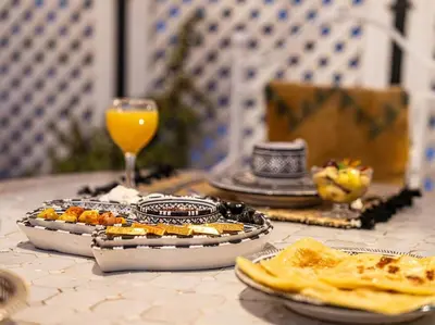 a table with a plate of food and a glass of orange juice at Authentic house in the old Medina of Marrakech in Marrakech