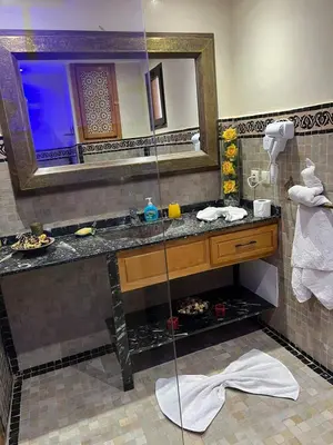 a bathroom with a sink and a mirror at Appartement élégant avec vue sur piscine jardin verdoyant et wifi ultra rapide in Marrakech