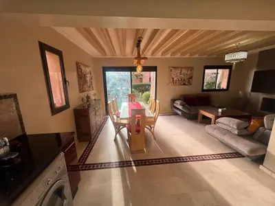a living room with a table and a couch at Appartement élégant avec vue sur piscine jardin verdoyant et wifi ultra rapide in Marrakech