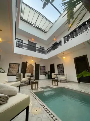 a living room with an indoor pool with a skylight at Riad Awatif le 36 in Marrakech