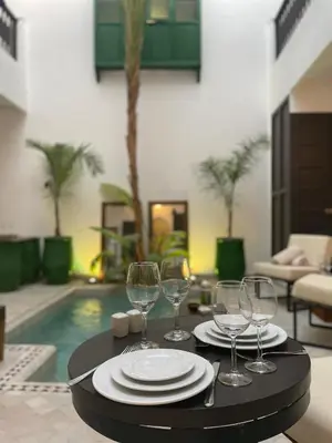 a table with plates and wine glasses on it at Riad Awatif le 36 in Marrakech