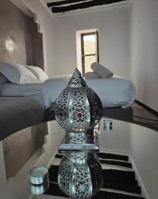 a silver vase sitting on a glass table in a room at Riad Awatif le 36 in Marrakech