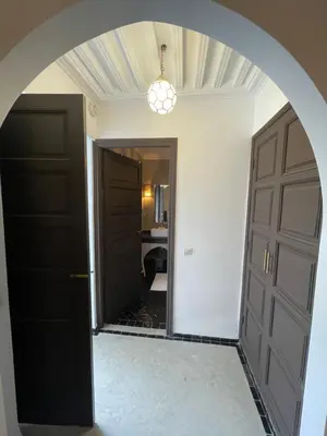 a hallway with two black doors and a mirror at Riad Awatif le 36 in Marrakech
