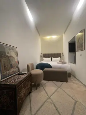 a hotel room with a bed and a couch at Riad Awatif le 36 in Marrakech
