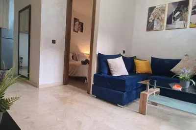 a living room with a blue couch and a table at appartement de luxe gueliz in Marrakech