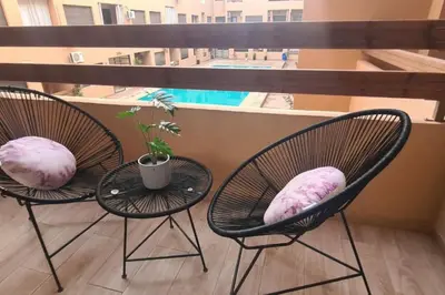 two chairs with pillows sitting on a balcony at appartement de luxe gueliz in Marrakech