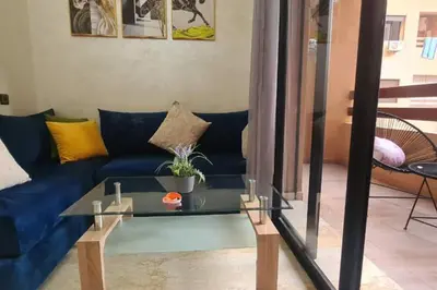 a living room with a blue couch and a glass table at appartement de luxe gueliz in Marrakech