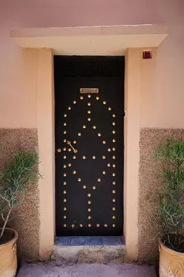 a black door with a lot of lights on it at Riad Kbala in Marrakech