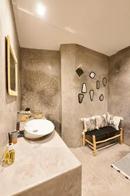 a bathroom with a sink and a couch in a room at Riad Kbala in Marrakech