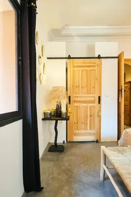 a room with a wooden door and a table at Riad Kbala in Marrakech
