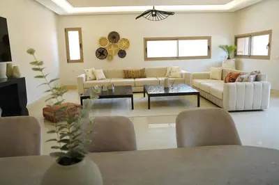 a living room with a couch and a table at Villa Home Orient Avec Piscine Privée 3 Chambres in Marrakech