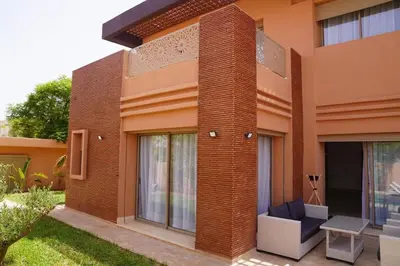 a red brick building with a bench in front of it at Villa Home Orient Avec Piscine Privée 3 Chambres in Marrakech