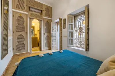 a bedroom with a blue rug and a window at Riad Chill&Relax Dar Tayri in Marrakech
