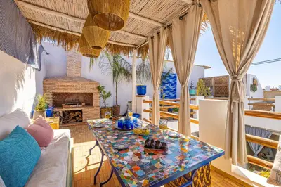 a living room with a table and a fireplace at Riad Chill&Relax Dar Tayri in Marrakech