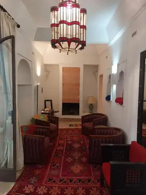 a living room with couches and a chandelier at Riad Dar Lalla Fatna in Marrakech