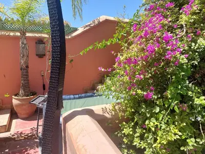 a villa with a swimming pool and flowers at Riad Dar Lalla Fatna in Marrakech