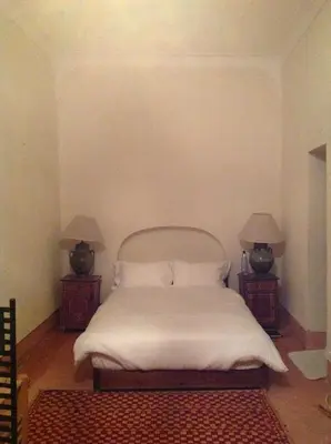 a bedroom with a white bed with two night stands at Riad Dar Lalla Fatna in Marrakech