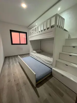 a bedroom with two bunk beds and a window at Appartement avec piscine in Marrakech