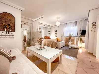 a living room with a couch and a bed and a table at Studio au coeur de Guéliz in Marrakech
