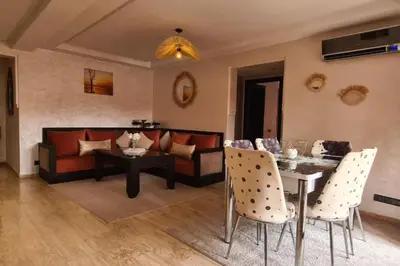 a living room with a couch and a table and chairs at appartement 2 chambres en plein centre ville gueliz marrakech in Marrakech